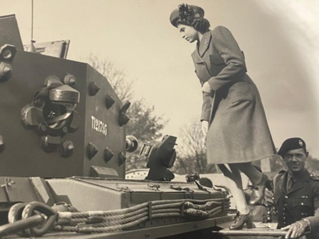 Princess Elizabeth. 19, climbs a tank just weeks after the end of World War II in never-before-published archives. Picture: Getty Images