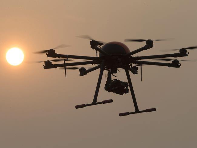 In this Oct. 17, 2015 photo, a drone hovers with the sun in the background near a school run by TT Aviation Technology in Beijing. TT Aviation Technology Co. - and their instructors - are part of a new cottage industry sprouting up in China, where drones are being deployed in rising numbers and touted as a game-changer in agriculture, logistics, film production and law enforcement. (AP Photo/Ng Han Guan)