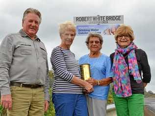 Robert White's great grandson Chris Mitchell, great granddaughter Lyn McLean, granddaughter Phyllis Mitchell and great granddaughter Jill McCann with the newly erected sign and an artillery shell that was presented to Alderman White and his wife Elizabeth at the bridge opening in 1926. It was engraved as a "token of esteem by residents of South Lismore". Picture: Terra Sword