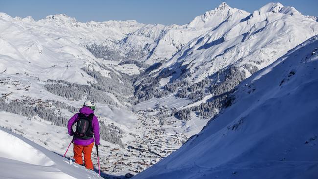 A skier looking down on the town of Lech, Austria.