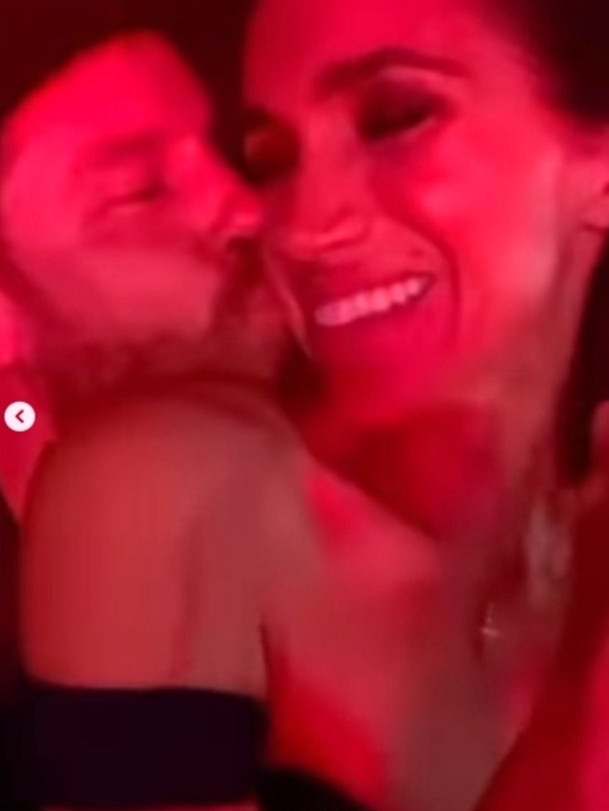 The couple share a kiss.