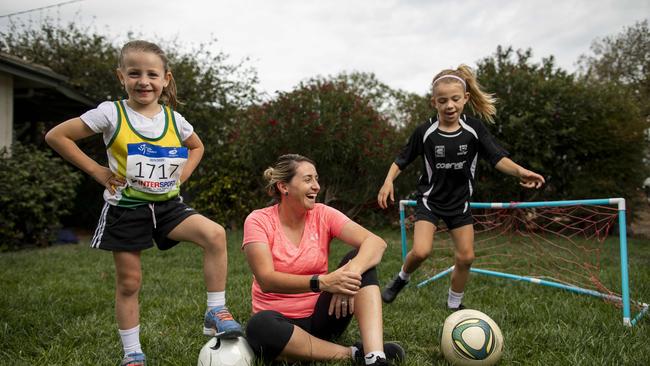 Soccer coach Heather Garriock with her daughters Noa, 5, left, and Kaizen, 7, right at home in Canberra. Picture: Sean Davey