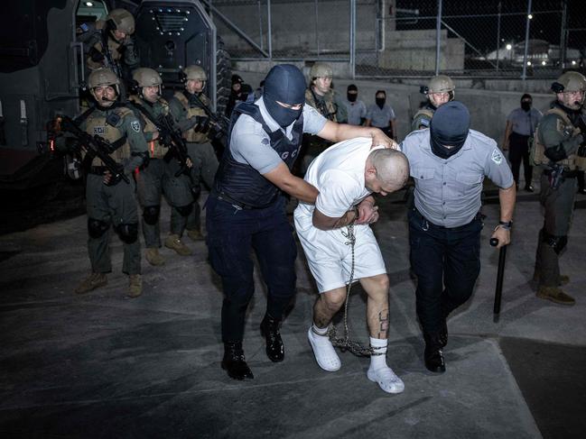 Guards drag alleged members of the Venezuelan criminal organisation Tren de Aragua into the prison. Picture: AFP