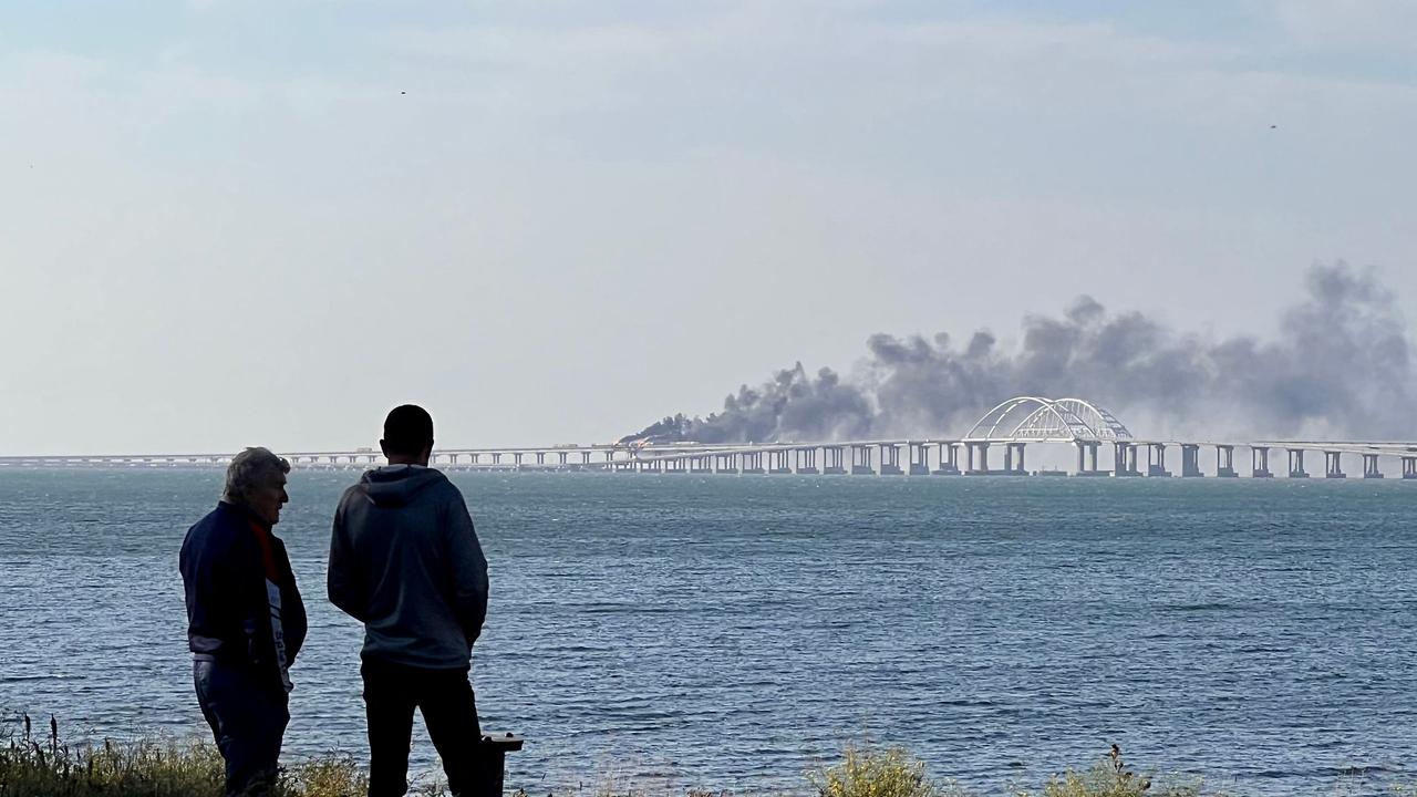 People look at thick black smoke rising from a fire on the Kerch bridge. Picture: Roman Dmitriyev / AFP