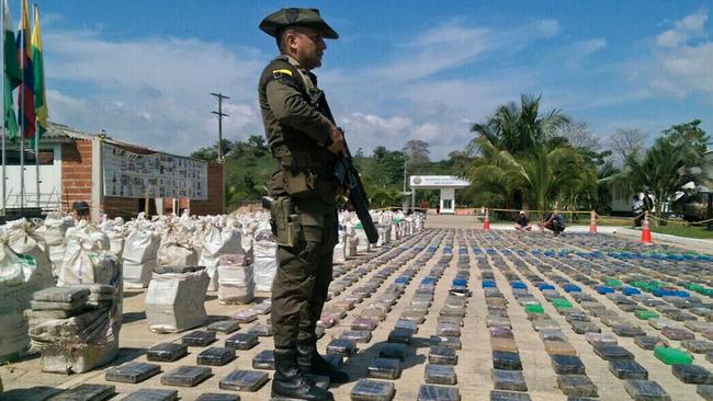 A Colombian police officer standing guard over eight tons of seized cocaine in Turbo, Antioquia department, in May 2016. Picture: AFP