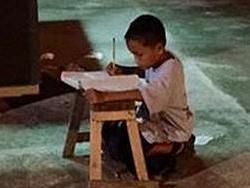 Daniel Cabrera studies by the faint light of a McDonald's in the Philippines.