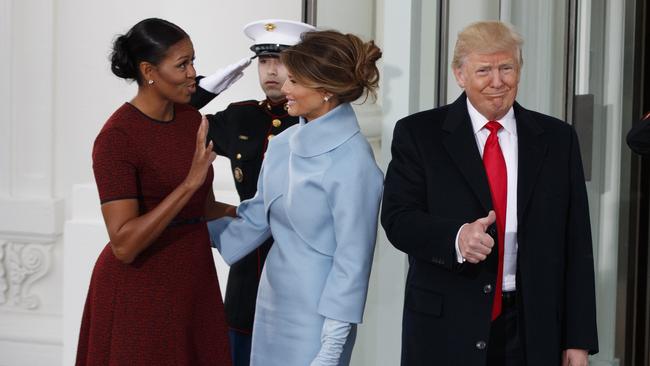 President-elect Donald Trump gives a thumbs-up as first lady Michelle Obama and Melania Trump talk at the White House in Washington, Friday, Jan. 20, 2017. (AP Photo/Evan Vucci)