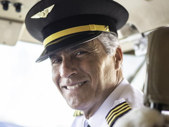 Portrait of airplane pilot looking over shoulder in a private jet