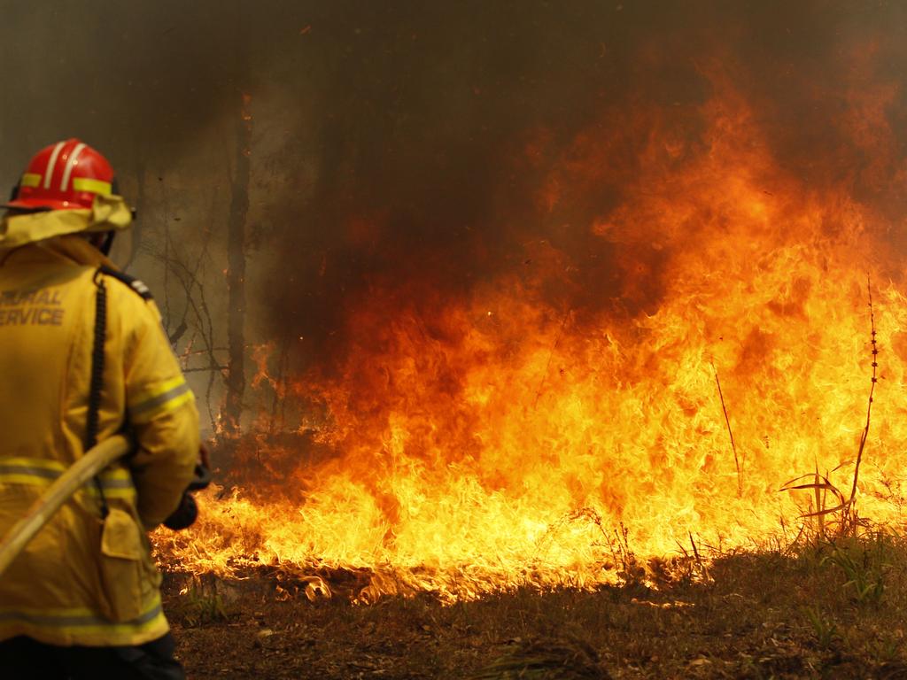 Firefighters work to contain a bushfire along Old Bar Road in Old Bar, NSW. Picture: Darren Pateman/AAP