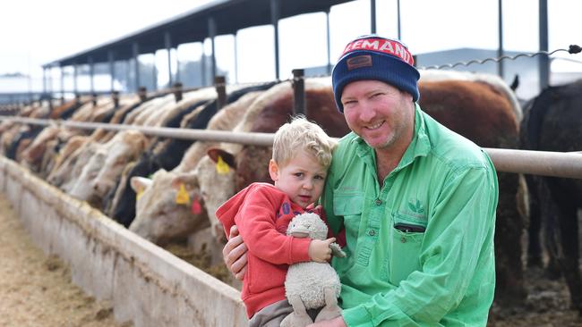 Jason Palmer and son Sam, 2, at the feedlot. Picture: Zoe Phillips