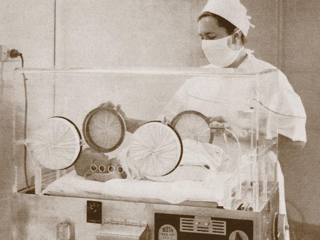 A nurse checks a baby in the incubator in the 1930s. Picture: Sydney Local Health District