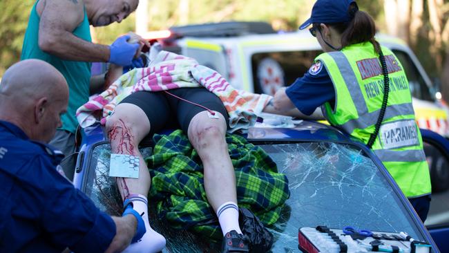 Paramedics — including one off duty — treat cyclist Peter Franc as he lies on the roof of a car. Picture: Charlie Coquillard