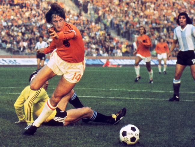 (FILES) This file photo taken on June 26, 1974 shows Dutch midfielder Johann Cruyff dribbling past Argentinian goalkeeper Daniel Carnevali on his way to scoring a goal during the World Cup quarterfinal soccer match between the Netherlands and Argentina on June, 26, 1974 in Gelsenkirchen. Johan Cruyff, one of the greatest footballers in history, died on March 24, 2016 at the age of 68 after losing his battle with cancer, it was announced on his official Twitter account. / AFP PHOTO / STF