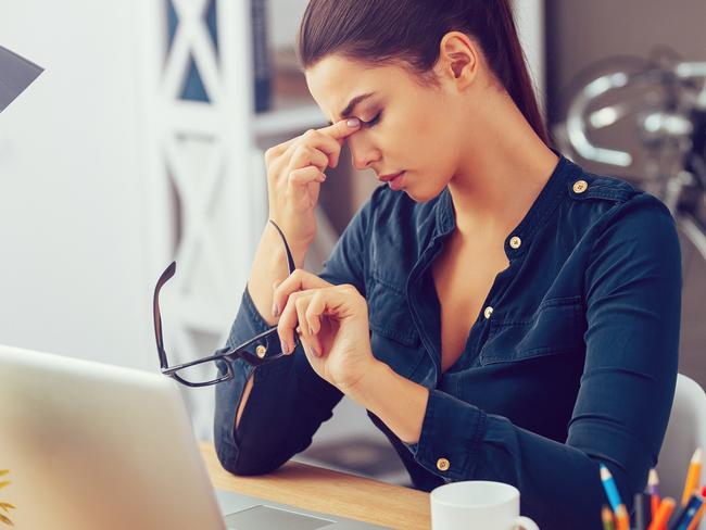 Feeling Great - August 1 Frustrated young woman keeping eyes closed and massaging nose while sitting at her working place in office