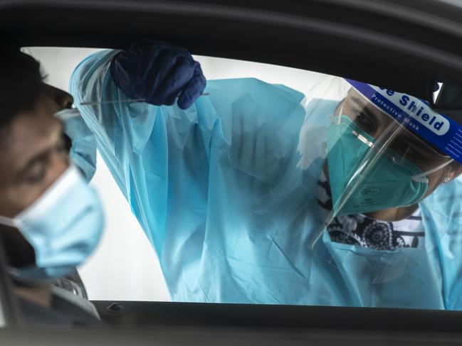 A health worker carries out a COVID-19 testing at the Merrylands drive-through clinic in early January at Sydney. Picture: Brook Mitchell/Getty Images