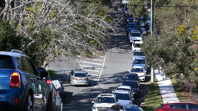 Traffic backs up to suburban streets as residents are tested for Covid-19 at a pop up testing clinic at Indooroopilly State High School. Picture: Jono Searle