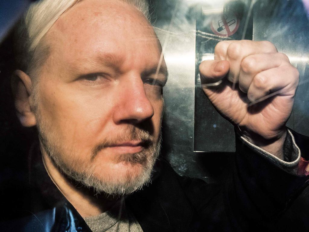 WikiLeaks founder Julian Assange gestures from the window of a prison van as he is driven into Southwark Crown Court in London, before being sentenced to 50 weeks in prison for breaching his bail conditions in 2012. Picture: Daniel Leal-Olivas / AFP