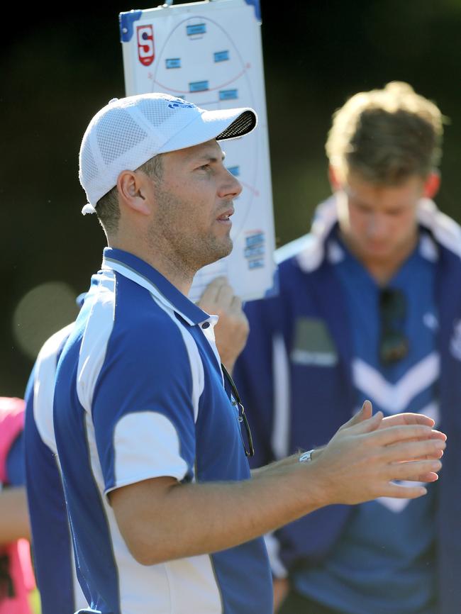 SPOC coach Chris Hall talks to his players at quarter-time. Picture Dean Martin