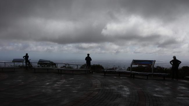 People maintain their social distancing while watching rain clouds form at the Mount Lofty lookout in early April. Picture: Emma Brasier/AAP