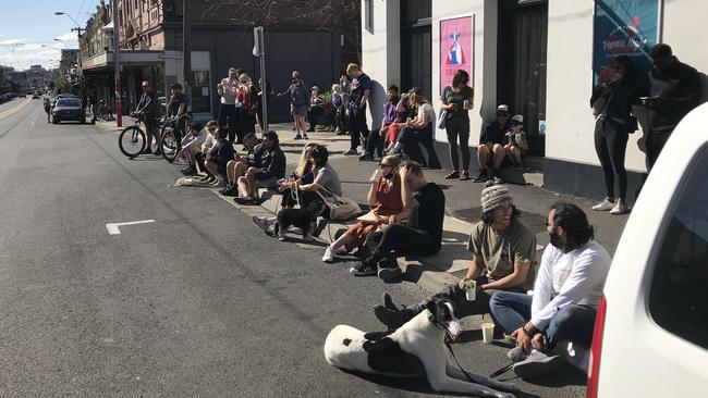 Revellers sit in the gutter, listening to music. Picture: Josie Hayden