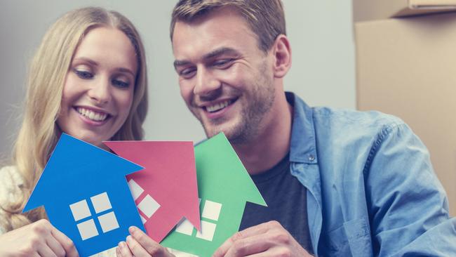 Leader Hot Topic - should you buy a second house - iStock stock photo couple with multiple homes, property investment, house purchaseCouple with 3 house symbols Ã¢Â€Â“ choice concept. They are sitting down, smiling, both casually dressed and holding green, blue and red house symbols which could represent also environmental conservation or home ownership, or property development.