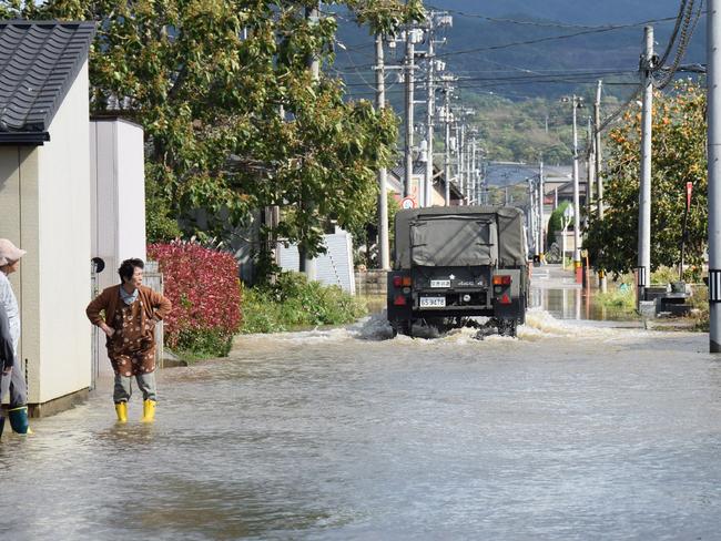 A Japanese Ground Self-Defense Forces vehicle surveys a flooded road in Date, Fukushima prefecture. Picture: AFP/Japan OUT