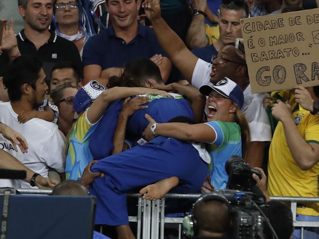 Brazil's Rafaela Silva celebrates after defeating Mongolia's Sumiya Dorjsuren during their women's -57kg judo contest gold medal match of the Rio 2016 Olympic Games in Rio de Janeiro on August 8, 2016. / AFP PHOTO / Jack GUEZ