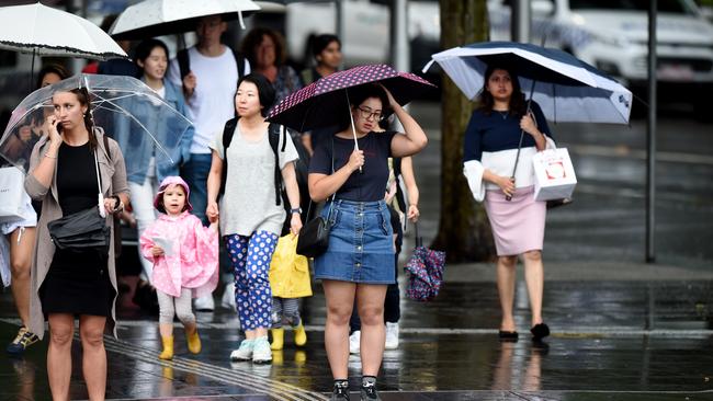 Pedestrians shelter under umbrellas in Melbourne on Friday.