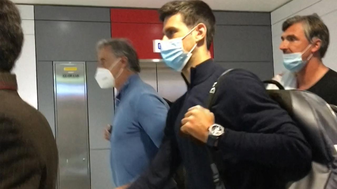 Novak Djokovic (C) has arrived in Adelaide Airport less than a year after he was deported from the country over his vaccination status, pictured here in 2021. Picture: AFPTV / AFP