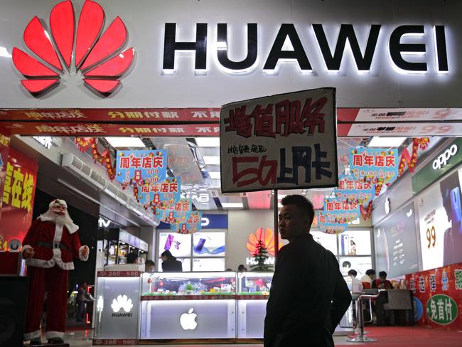 A worker holds a sign promoting a sale for Huawei 5G internet services in China. Picture: AP