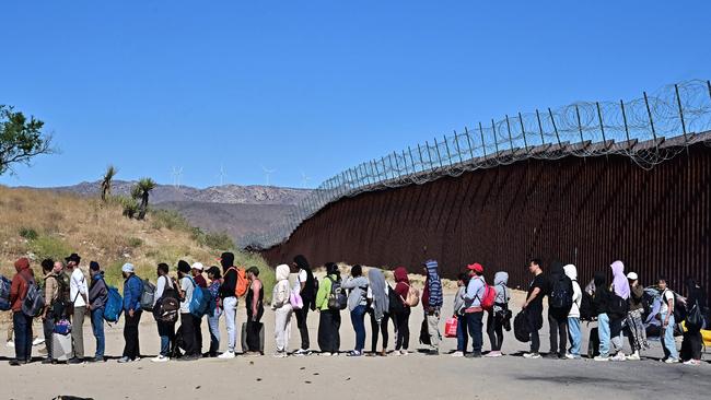 Migrants wait in line hoping for processing from Customs and Border Patrol agents after groups arrived at Jacumba Hot Springs, California. Picture: Frederic J. Brown/AFP