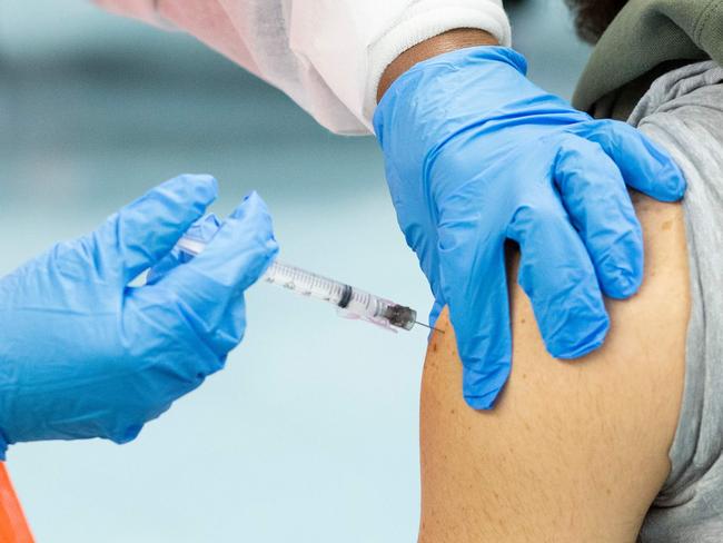(FILES) In this file photo a man receives a dose of the Moderna coronavirus disease (COVID-19) vaccine at a vaccination site at South Bronx Educational Campus, in the Bronx New York on January 10, 2021. - US biotechnology firm Moderna on January 25, 2021 said lab studies showed its Covid-19 vaccine would remain protective against variants of the coronavirus first identified in the United Kingdom and South Africa. 