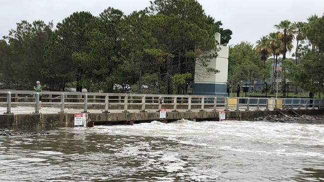 A man on the flooded Bond University weir in Lake Orr. Picture: Laura Nelson