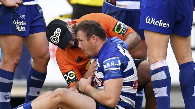 Josh Morris of the Bulldogs receives attention from a trainer after a hit from Sam Burgess of the Rabbitohs during the Round 4 NRL match between the South Sydney Rabbitohs and the Canterbury-Bankstown Bulldogs at ANZ Stadium in Sydney, Friday, March 30, 2018. (AAP Image/Dan Himbrechts) NO ARCHIVING, EDITORIAL USE ONLY