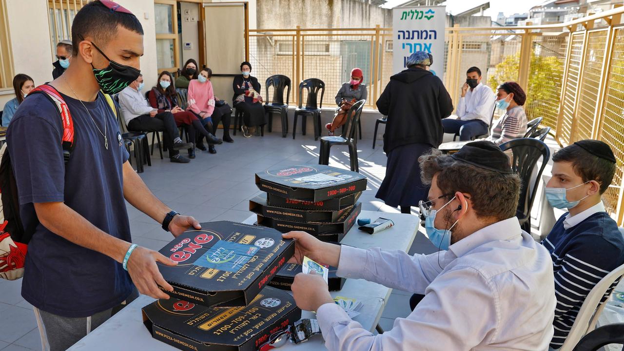 A person receives a pizza after getting a dose of the Pfizer-BioNtech COVID-19 coronavirus vaccine. Picture: JACK GUEZ / AFP.