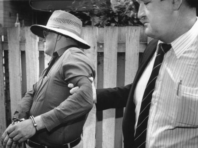 A detective holds on to David Eastman when he was chief suspect in the shooting death of Colin Winchester. Picture: Library