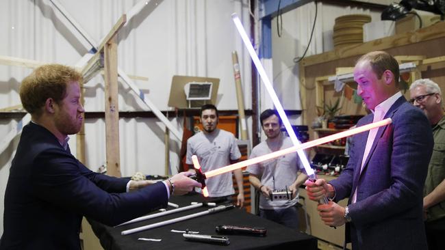 Prince Harry and Prince William try out light sabres during a tour of the Star Wars sets at Pinewood studios in 2016, in England. Picture: Getty