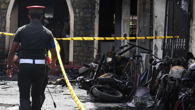 Sri Lankan security personnel walk past debris outside Zion Church in Batticaloa. Picture: AFP 