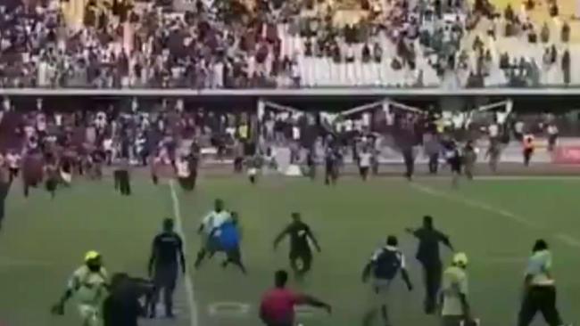 Fans run onto the field as a brawl breaks out at a PNG rugby league semi final.