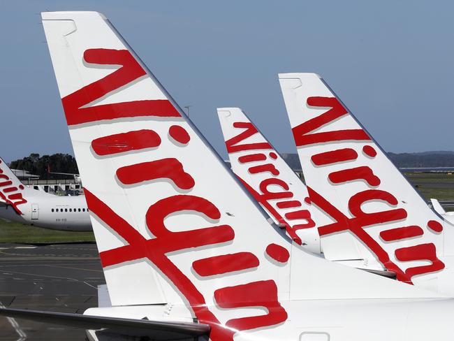 Virgin Australia planes are lined up at departure gates at Sydney Airport in Sydney, Wednesday, April 22, 2020. Virgin Australia is seeking bankruptcy protection, entering voluntary administration after a debt crisis worsened by the coronavirus shutdown pushed it into insolvency. (AP Photo/Rick Rycroft)