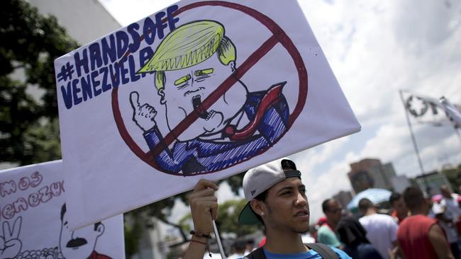 A government supporter holds a placard against Trump on September 19. Picture: Ariana Cubillos