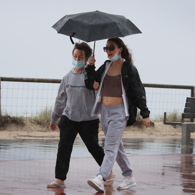Day three of the Gold Coast lockdown. People and pidgeons keep dry at Surfers Paradise. Picture Glenn Hampson