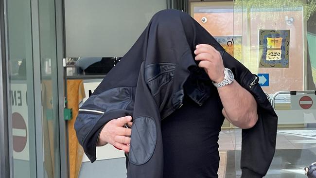 Summer Hill's John Elia hid his face when he left Sutherland Local Court where he was sentenced for assault and intimidation for standing over an accountant he owed his friend $15,000. Picture: Ashleigh Tullis