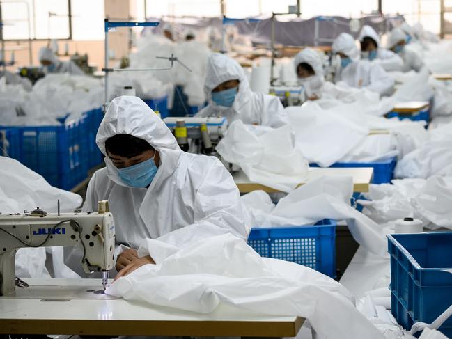 TOPSHOT - This photo taken on February 28, 2020, shows workers sewing at factory making hazardous material suits to be used in the COVID-19 coronavirus outbreak, at the Zhejiang Ugly Duck Industry garment factory in Wenzhou. - The coronavirus outbreak in China is preventing clothing manufacturer Ugly Duck Industry from resuming its normal production of winter coats, so it has pivoted to another in-demand product: hazmat suits. (Photo by NOEL CELIS / AFP) / TO GO WITH AFP STORY HEALTH-VIRUS-CHINA-HAZMAT-FACTORY,SCENE BY DAN MARTIN