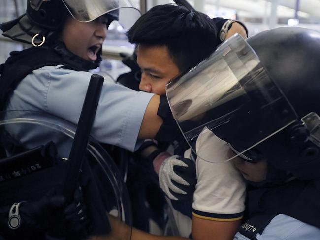 Policemen in riot gear arrest a protester during a demonstration at Hong Kong’s international airport. Picture: AP