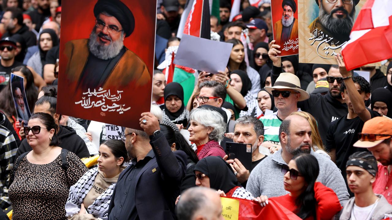 People hold up pictures of Hezbollah leader Hassan Nasrallah at a protest at Town Hall in Sydney on September 29. Picture: NewsWire / Damian Shaw