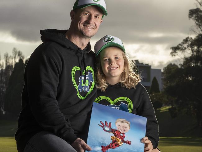 Damien Green and his son Maison 8 hold a picture of Archie at Hobart. Picture: Chris Kidd