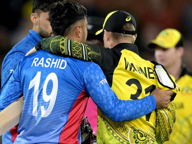 Australia's David Warner (R) embraces Afghanistan's Rashid Khan after the ICC men's Twenty20 World Cup 2022 cricket match between Australia and Afghanistan at Adelaide Oval on November 4, 2022 in Adelaide. (Photo by Brenton EDWARDS / AFP) / -- IMAGE RESTRICTED TO EDITORIAL USE - STRICTLY NO COMMERCIAL USE --