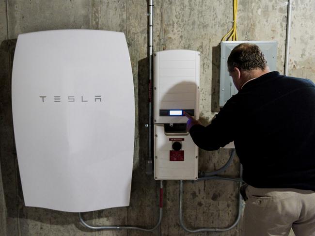 A customer inspects a Tesla Motors Inc. Powerwall unit inside a home in Monkton, Vermont, U.S., on Monday, May 2, 2016. A year after Elon Musk unveiled the Powerwall at Tesla Motors Inc.’s design studio near Los Angeles, the first wave of residential installations has started in the U.S. The 6.4-kilowatt-hour unit stores electricity from home solar systems and provides backup in the case of a conventional outage. Photographer: Ian Thomas Jansen-Lonnquist/Bloomberg