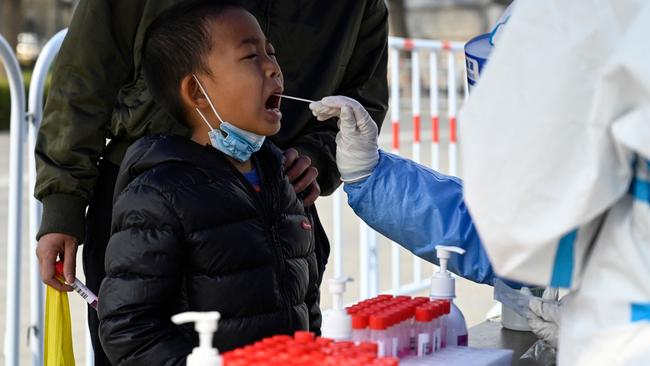 A health worker takes a swab sample from a boy to be tested for Covid-19 in Beijing on Wednesday. Picture: AFP